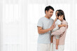 © geargodz - father and mother holding and hugging with toddler baby on white window background. happy family