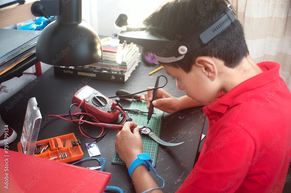 Kids Using Multimeter Boy using a multimeter to check voltage and repair a watch Stock Photo ...