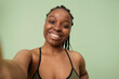 © AnnaStills - Medium close-up POV of self-confident gen Z Black girl with no makeup standing in studio taking selfie