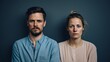 © Khuram Ibn Sabir - Serious, stressed and Worried Couple Against Solid Blue Studio Background