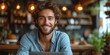 © Attasit - Happy young man sitting in front of a laptop working at home, natural colors light background