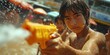A young people are using water guns play in the summer enjoy the splashing Songkran Festival