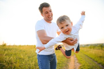 Happy father playing with son on sunset background .The concept of father's day