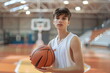 A young boy holding a basketball on a basketball court