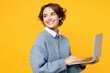 © ViDi Studio - Side view young fun IT woman she wears grey knitted sweater shirt casual clothes hold use work on laptop pc computer look aside isolated on plain yellow background studio portrait. Lifestyle concept.