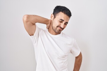 Sticker - Handsome hispanic man standing over white background suffering of neck ache injury, touching neck with hand, muscular pain