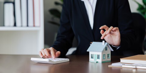 Wall Mural - Agent worker are using calculator to calculate home loan interest rates for customers