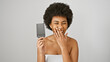 Laughing african woman holding comb against a white background, portraying casual beauty and joy.