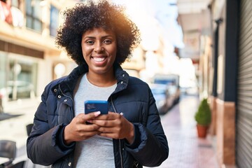 Poster - African american woman smiling confident using smartphone at street