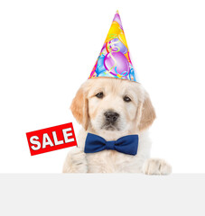 Wall Mural - Golden retriever puppy wearing tie bow and party cap shows signboard with labeled 