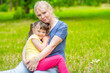 © Ermolaev Alexandr - Woman hugs smiling little girl with syndrome down at summer park. Empty space for text