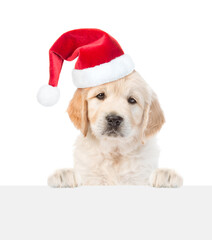 Poster - Cute Golden retriever puppy wearing santa hat looks above empty white banner. isolated on white background