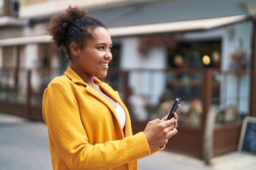 Wall Mural - African american woman smiling confident using smartphone at coffee shop terrace