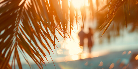 Wall Mural - Blurred background silhouette of a romantic couple in romantic or honeymoon trip , framed by palm leaves