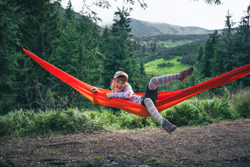 Poster - little cute girl at hammock in mountains