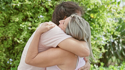 Wall Mural - Confident mother and son share a joyful, sunny hug in the park, happily stage an expression of love, positivity, and family togetherness amidst nature