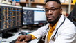 © weerasak - Confident male doctor working at a desk with multiple computer screens showing medical data.