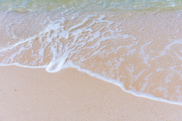 green sea, white bubble waves,and clear sand landscape aerial top view sea waves seamless loop on the white sand beach. Wave after wave swept towards the shore. green sea, white bubble 