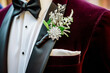 crystalembellished boutonniere on a velvet tuxedo at a gala event