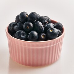 Poster -  Delicious group of blueberries on ceramic bowl over isolated white background