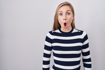 Poster - Young caucasian woman wearing casual navy sweater afraid and shocked with surprise expression, fear and excited face.