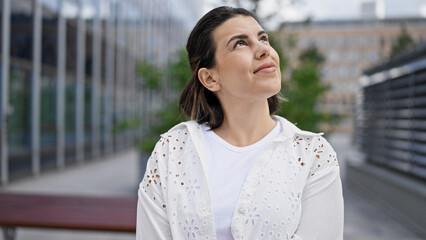 Wall Mural - Beautiful young hispanic woman smiling confident looking to the side in the streets of Stockholm