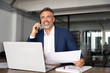 © Stock 4 You - Happy smile Hispanic businessman talking phone and hear good news, checking database in office. Latin business man holding document, working at laptop computer doing online trade market tech research.