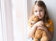 Caucasian child girl portrait empty copy space. Female kid with teddy bear toy. Toddler seriuos face closeup, person look.Childhood.