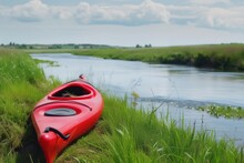 Red Kayak On River Bank, Green Grass, Calm Water Flowing