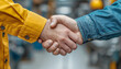 © MarijaBazarova - Two industrial engineers, builders, foreman making a handshake together,  shaking hand with congratulate. Blue and yellow colors of clothes
