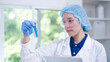 © Supapich - Professional expertise woman research scientist compare blue liquid in test tube or glassware beaker in chemical scientific experiment laboratory, female doctor pharmacy biology medicine person