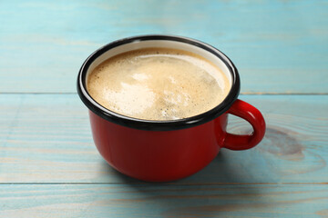 Wall Mural - Cup of aromatic coffee on light blue wooden table, closeup