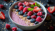 Yummy Berry smoothie bowl with granola, strawberries, blueberries, raspberries and mint leaves on dark stone background, side view, close-up. Vegan super food concept. Healthy breakfast