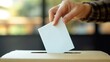 © Anna - hand casting a ballot into a box, focusing on the action of voting without showing the voter, highlighting the essence of democracy