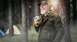© Chlorophylle - Homme aventurier quinquagénaire qui fait du camping et une randonnée dans la nature avec une tente et qui boit une tasse de café
