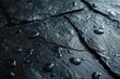 A detailed close up of water droplets on a sanitized and polished black surface.