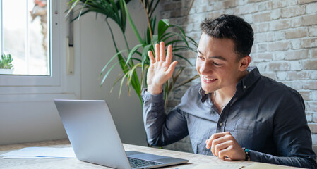 Wall Mural - Concentrated skilled millennial caucasian businessman in glasses wearing headphones with mic, taking part in online web camera negotiations meeting using computer app, distant communication concept..