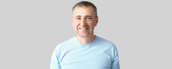 Poster - Portrait of handsome happy mature man on light background