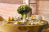 Fototapeta Mapy - Autumn table setting with flowers and pumpkins in dining room