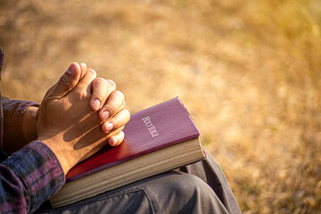 Silhouette of woman kneeling down praying for worship God at sky background