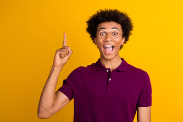 Canvas Print - Photo of cheerful excited man wear purple stylish clothes brilliant solution fingers up empty space isolated on yellow color background