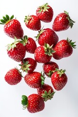Poster - Many red strawberries  fall down on white background 