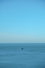 ship goes into the horizon of the blue sea, leaving a trail on the surface of the water landscape. Aerial view, concept of sea travel, cruises