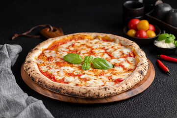 Wall Mural - pizza topped with fresh basil, tomato and cheese on top of wooden platter