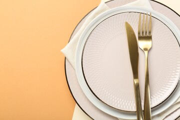 Poster - Ceramic plates, cutlery and napkin on color background, top view. Space for text