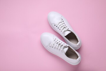 Sticker - Pair of stylish white sneakers on pink background, top view. Space for text