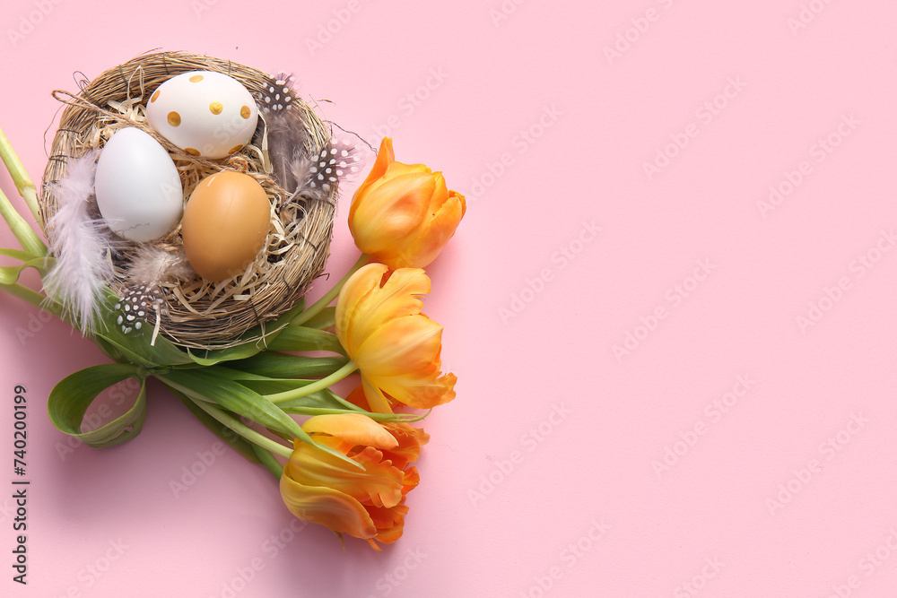 Nest with Easter eggs, feathers and tulip flowers on pink background