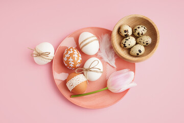 Poster - Plate and wooden bowl with Easter eggs and tulip on pink background