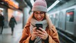 © Ilja - Stylish woman using mobile phone on underground train station platform for updates and information