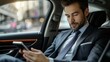 Successful businessman texting in luxury car, using smartphone in back seat of business vehicle